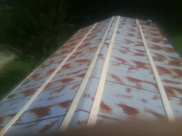 Rusted metal roof panels with new wood purlins before replacement — Storm Damage Roof Repair in Midway by Roofing Brothers